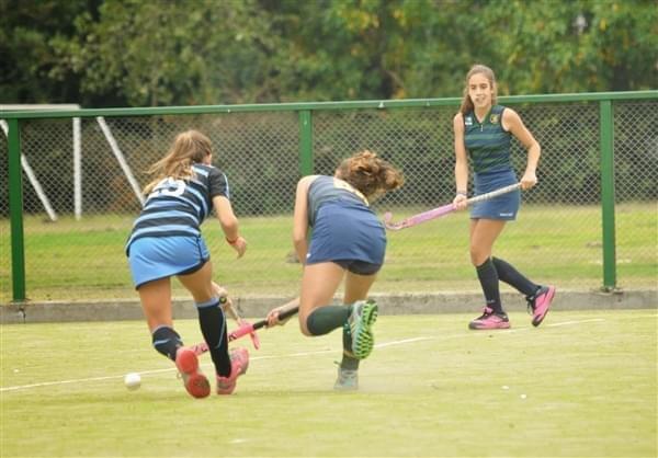 Field hockey turf with female athletes playing